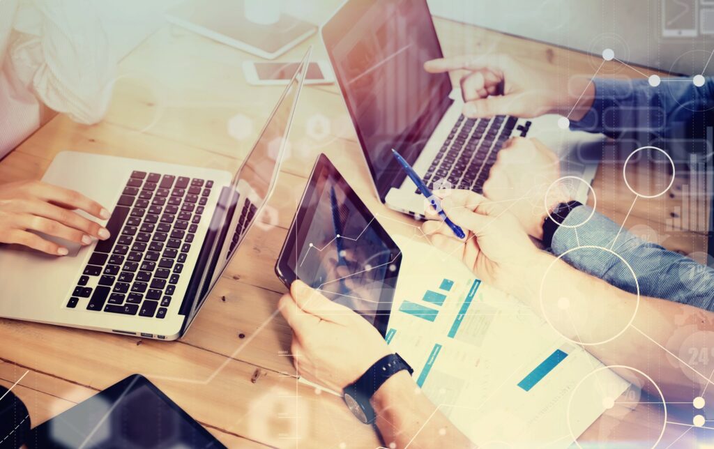 a close up of two people with laptops and a person with a tablet