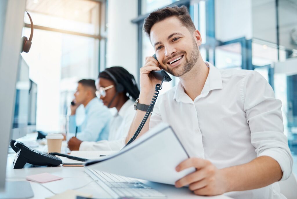 Man on the phone smiling at a call center