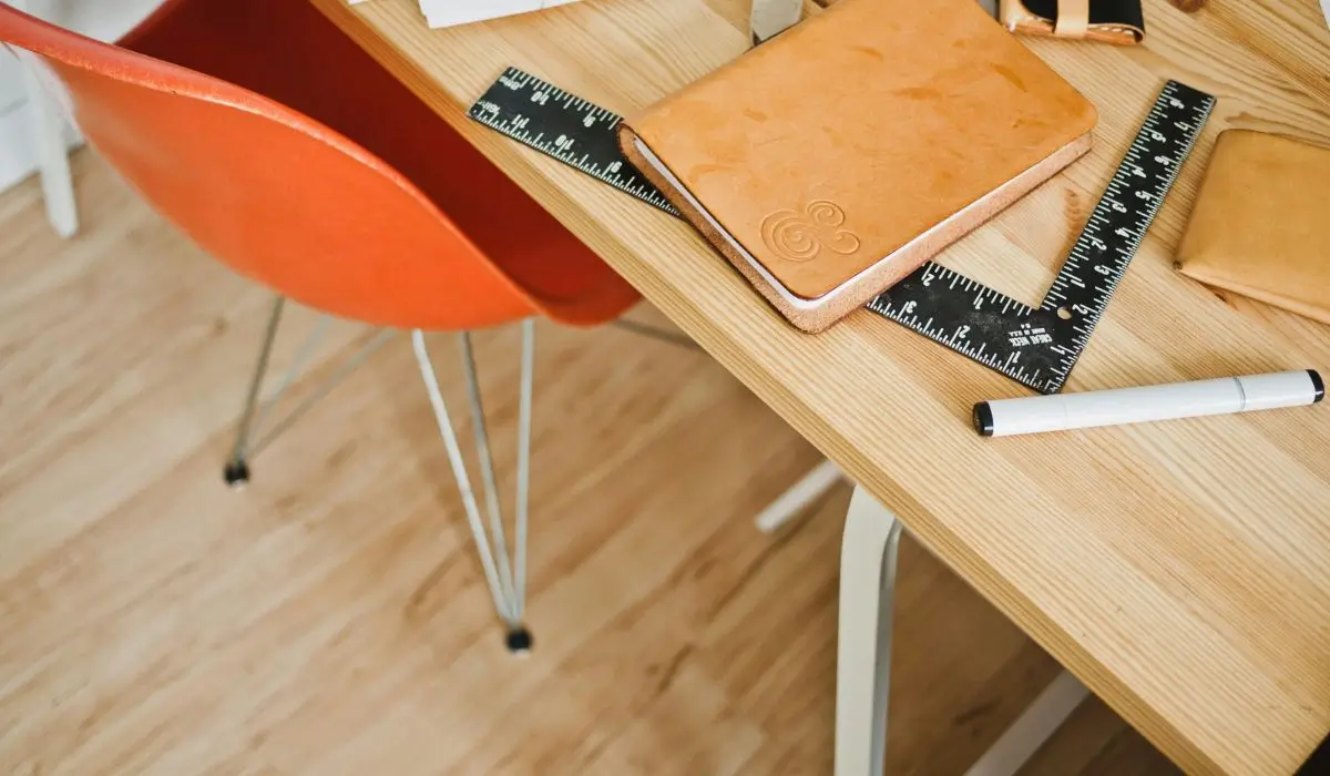 Modern interior design desk with essential tools, promoting creativity and planning in an interior design business mission.