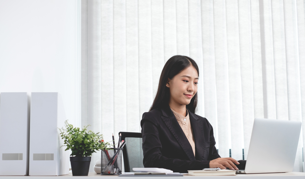 Professional working on a laptop in an office, showcasing business research service expertise.