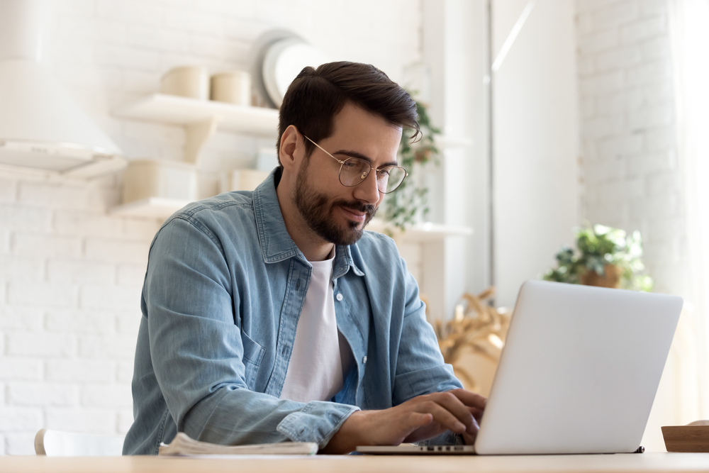 Professional working on a laptop in a home office environment, utilizing data analysis service tools.