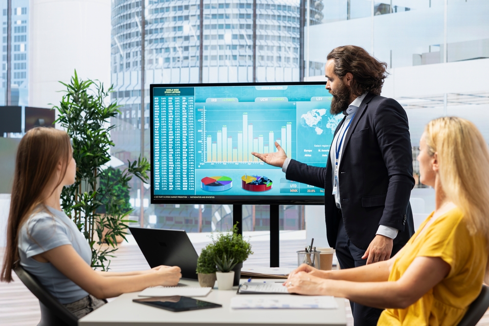A businessman delivers an analytical presentation to his colleagues, focusing on data-driven insights and clarity.