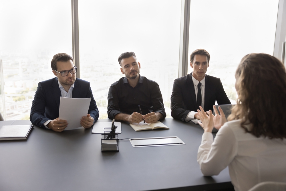 A group of business professionals engaged in discussion around a table during a training session.