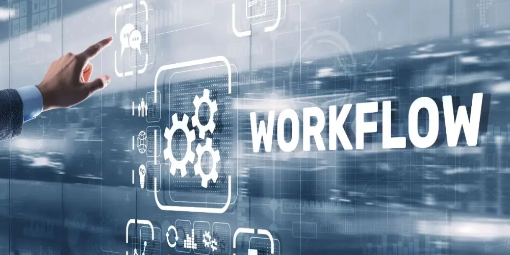 A hand interacting with a futuristic digital interface displaying the word 'WORKFLOW' alongside gear icons and data symbols, representing business process automation and optimization.