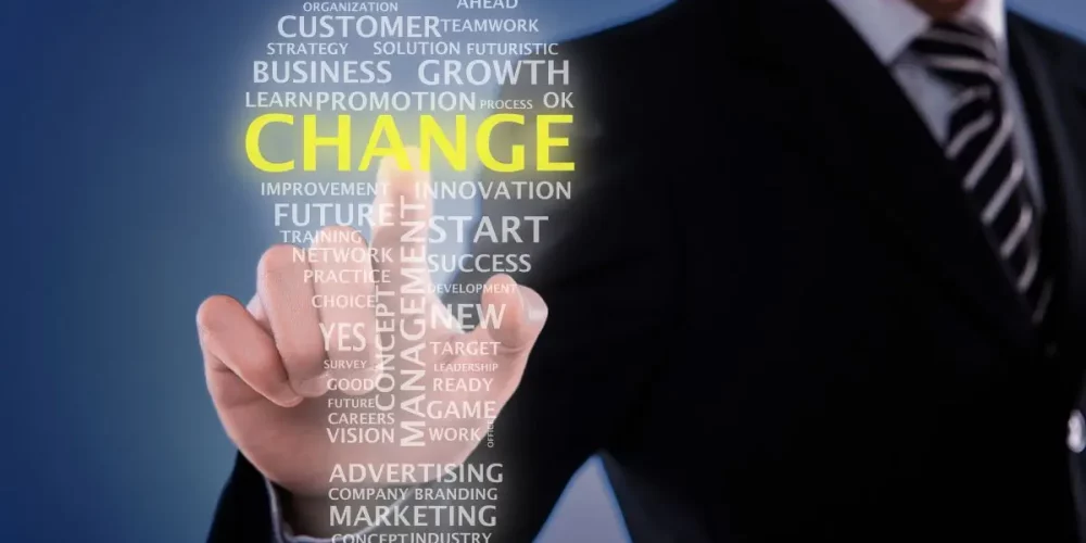 Business professional pointing to glowing “Change” text, symbolizing effective organizational change management through consulting expertise.